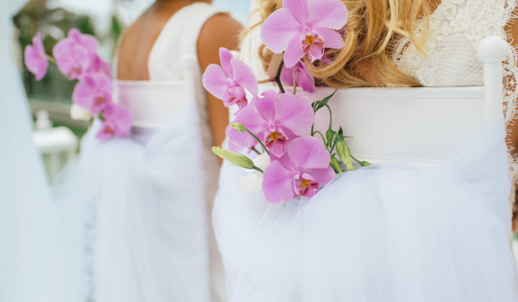 Floral decoration on a chair with orchids at wedding reception