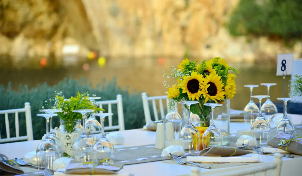 Outdoor wedding venue table setting with fresh sunflowers on the table