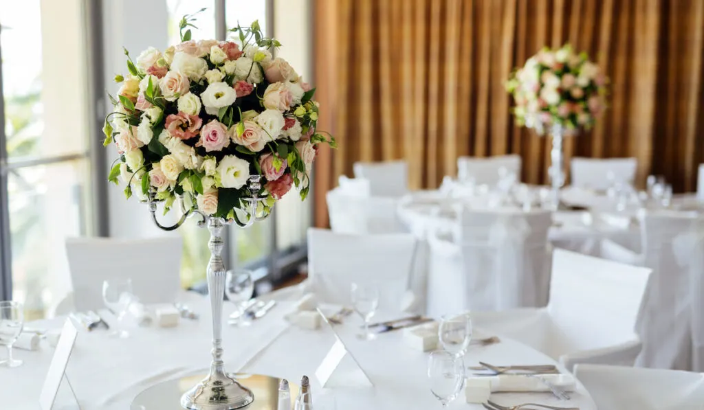 Wedding table with beautiful roses in bouquet on the center