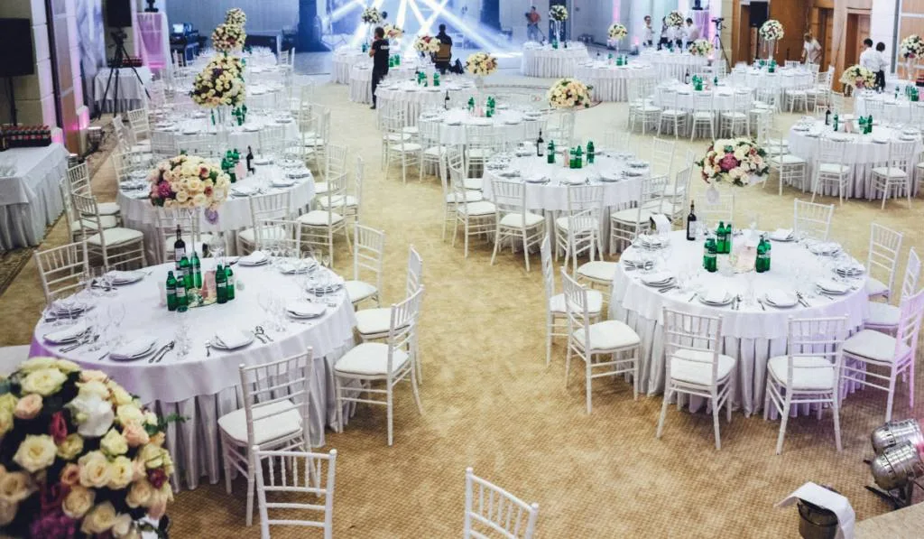Look from above at large restaurant's hall prepared for wedding dinner
