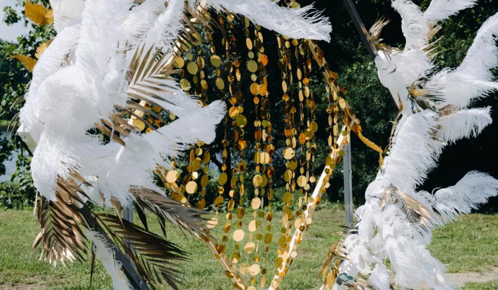 Decorated wedding arch in nature.Wedding ceremony with an arch decorated with feathers in retro
