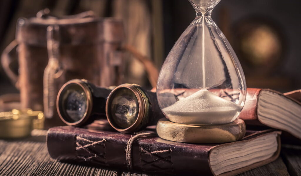 Old hourglass and journal