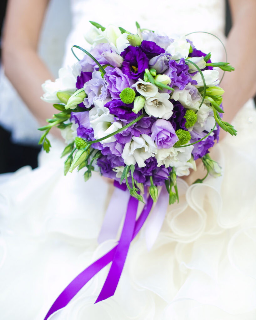 bride holding a beautiful purple bouquet 