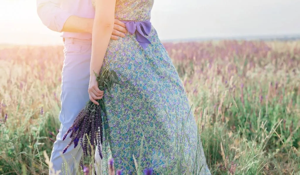 Cute couple in love hugging in a field of flowers