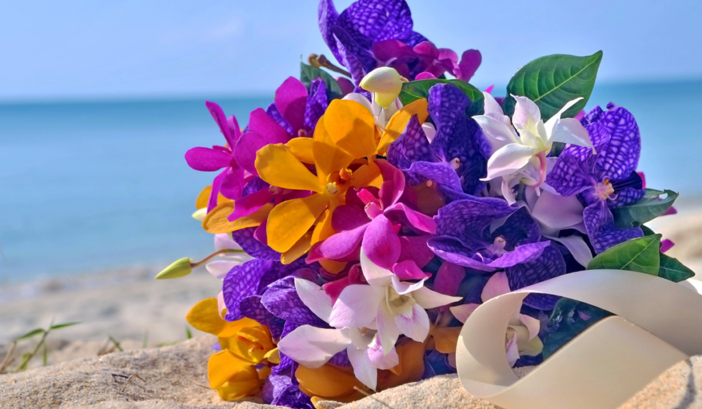 Orchids Bridal bouquet on the beach with a blue sky.
