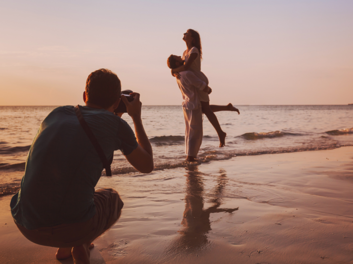 wedding portrait photographer taking photos of honeymoon couple on the beach at sunset, professional photography