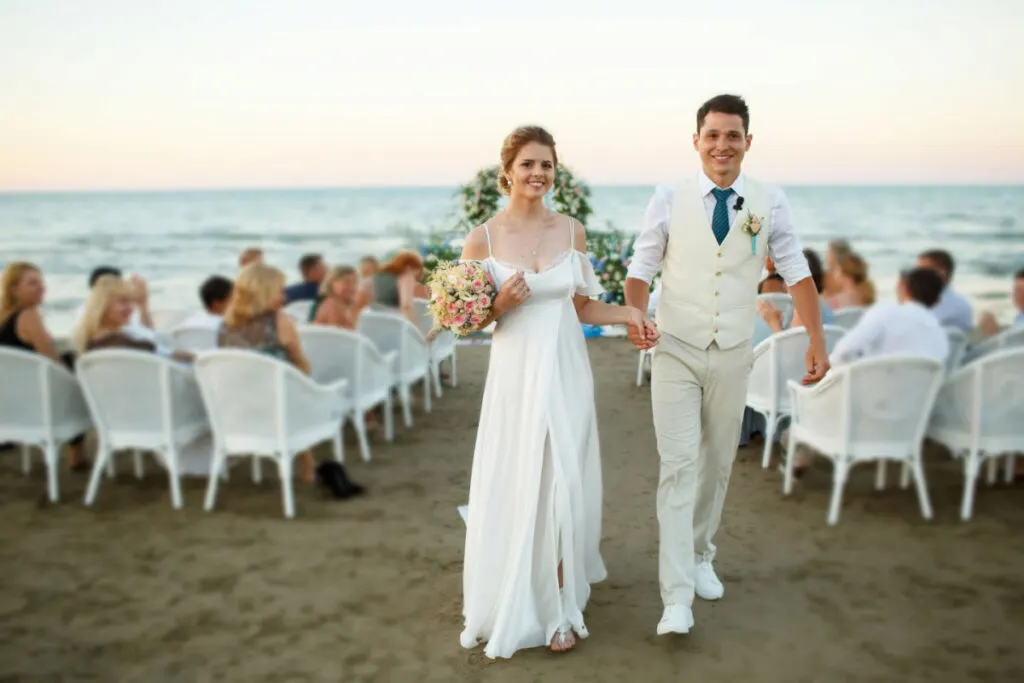 newly wed couple walking wearing a beach wedding attire